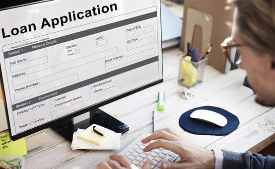 Photo of a man filling out an online loan application Photo of a man filling out an online loan application