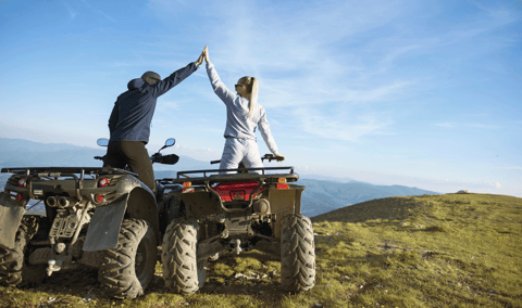 Photo of a couple riding ATVs