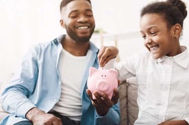 Girl and Father Putting Money in a Piggy Bank Girl and Father Putting Money in a Piggy Bank