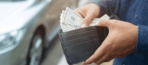 Photo of a man taking cash out of his wallet Photo of a man taking cash out of his wallet