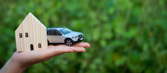 Photo of a small wooden house and a toy car in someone's hand. Photo of a small wooden house and a toy car in someone's hand.