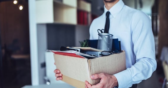 Photo of a man holding a box of his belongings. Photo of a man holding a box of his belongings.
