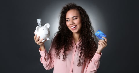 Woman holding a piggy bank and a credit card