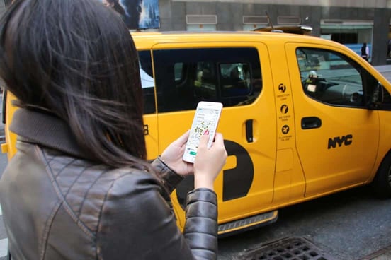 Photo of woman with Curb app and taxi Photo of woman with Curb app and taxi