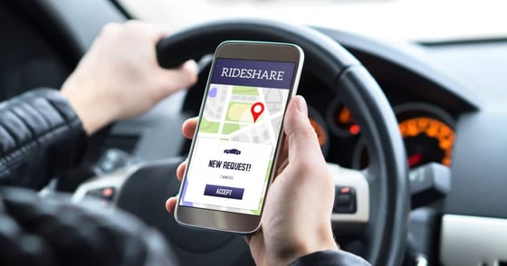 Rideshare driver in car using the rideshare app in mobile phone. Rideshare driver in car using the rideshare app in mobile phone.