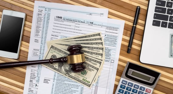 Gavel, tax form, money, calculator and laptop Gavel, tax form, money, calculator and laptop