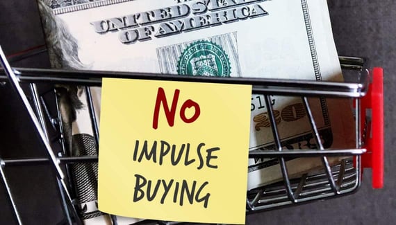 Red shopping cart with dollars on a dark background with text note NO IMPULSE BUYING