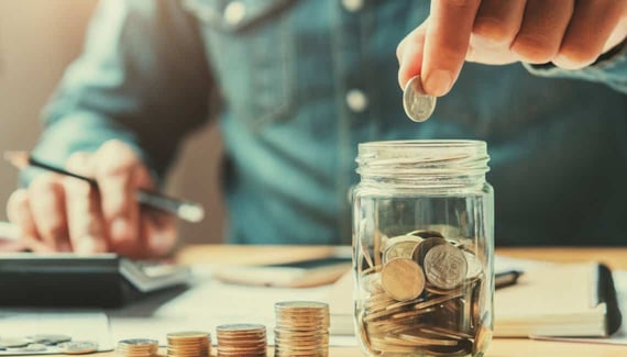 businessman holding coins putting in glass, saving money concept