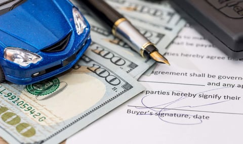 Image of a toy car with money and a signature