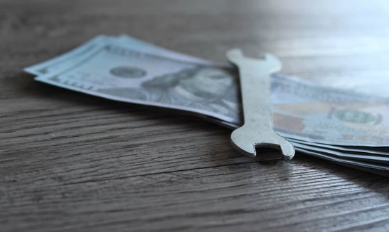 Wrench on top of dollars Wrench on top of dollars