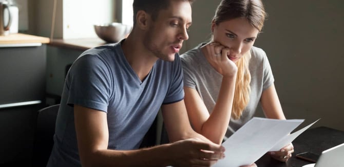 Couple sitting together reviewing a document Couple sitting together reviewing a document