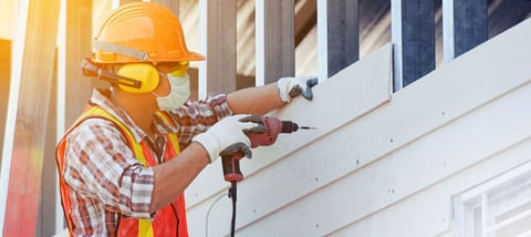 Construction worker with safety helmet and a drill, construction industry, new home, construction concept