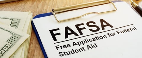 FAFSA text on a clipboard next to cash