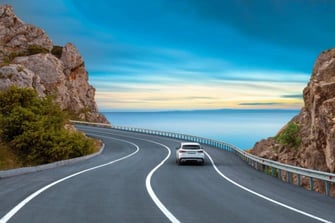 white car on a winding road white car on a winding road
