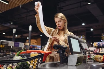 shopper at checkout surprised to see receipt totals shopper at checkout surprised to see receipt totals