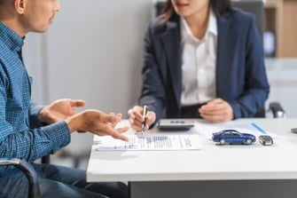 Photo of an Auto Lender Going Over Paperwork Photo of an Auto Lender Going Over Paperwork