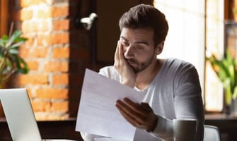 a frustrated man looking at a letter graphic a frustrated man looking at a letter graphic