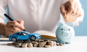 a person putting money in a piggy bank for a car graphic a person putting money in a piggy bank for a car graphic