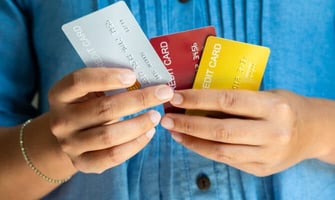 a woman holding three credit cards graphic