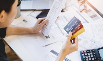 a woman looking multiple credit cards graphic