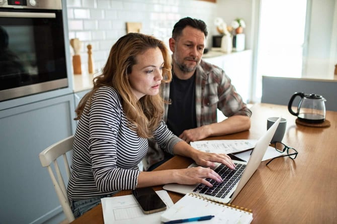 young couple reviewing bills laptop kitchen young couple reviewing bills laptop kitchen