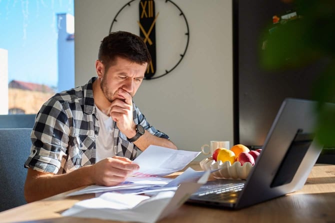 stressed person reviewing bills at home