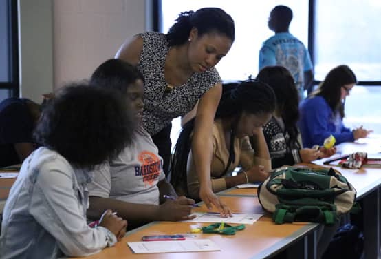 An image of a Credit Abuse Resistance Education (CARE) volunteer helping students An image of a Credit Abuse Resistance Education (CARE) volunteer helping students