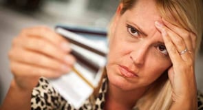 Image of a woman looking frustrated with her credit cards. 